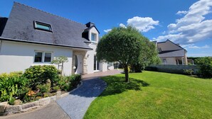 A modern two-story house with a sloped roof, a paved driveway, and a well-maintained lawn. - L'Olivier by Interhome (Erdeven)