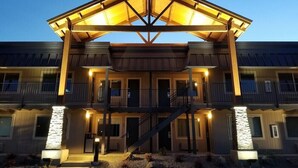 A hotel with a covered entrance, multiple balconies, and a staircase leading to the upper floors. - The Hotel Y, a Dazzler Select by Wyndham (YAKIMA)