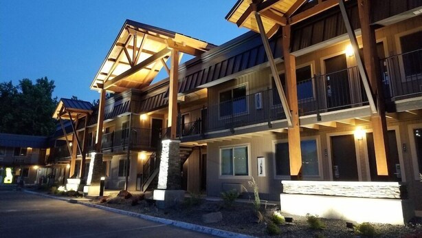 A multi-story hotel with balconies, a covered entrance, and a well-lit facade. - The Hotel Y, a Dazzler Select by Wyndham (YAKIMA)