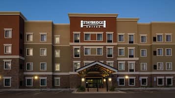 Un hotel de varios pisos con un cartel llamativo de Staybridge Suites.