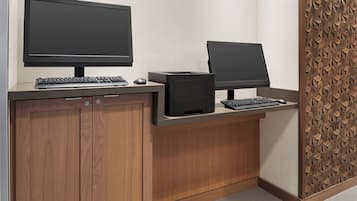 A reception desk with two monitors, a keyboard, and a mouse.