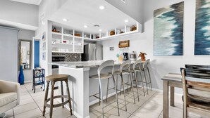 A modern kitchen with a central island, bar stools, and a dining table. - New Listing! Beachside gem, newly remodeled & redecorated  (South Padre Island)