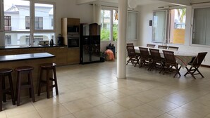 Une cuisine spacieuse avec un coin repas, de grandes fenêtres et une vue sur l’extérieur.