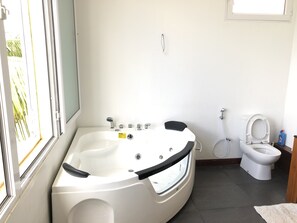 Een douche, een bubbelbad, handdoeken, toiletpapier
