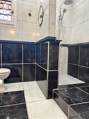 Een douche, een haardroger, een bidet, handdoeken