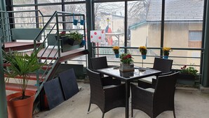 A balcony with wicker chairs, a glass table, and potted plants. - Résidence Les Mélèzes de Prades (Prades)