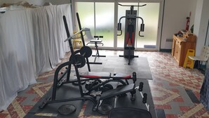 A gym with exercise equipment, a bench, and a mat. - Résidence Les Mélèzes de Prades (Prades)