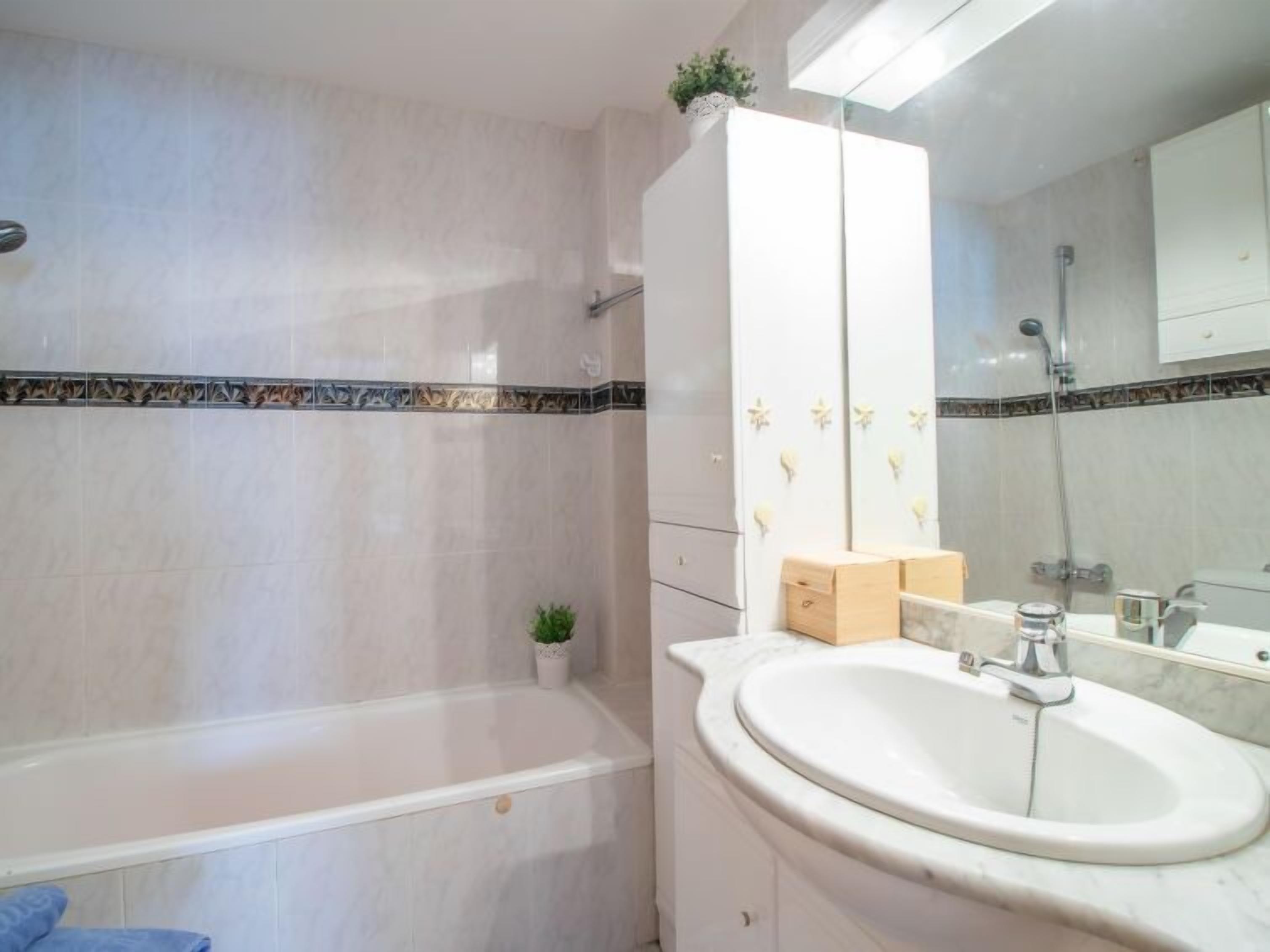 Ein Badezimmer mit Badewanne, Waschbecken und Spiegel.