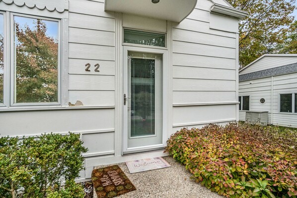 A white house with the number 22, a front door, and a welcome mat. - 🏖️Sleepy Hollow Beach Resort, Terrace 22 – Family Fun on Lake Michigan! (South Haven)