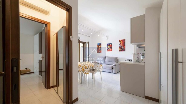 A modern apartment with a kitchen, dining area, and living room. - La Palma - Apartment with terrace and pool view (Lazise)