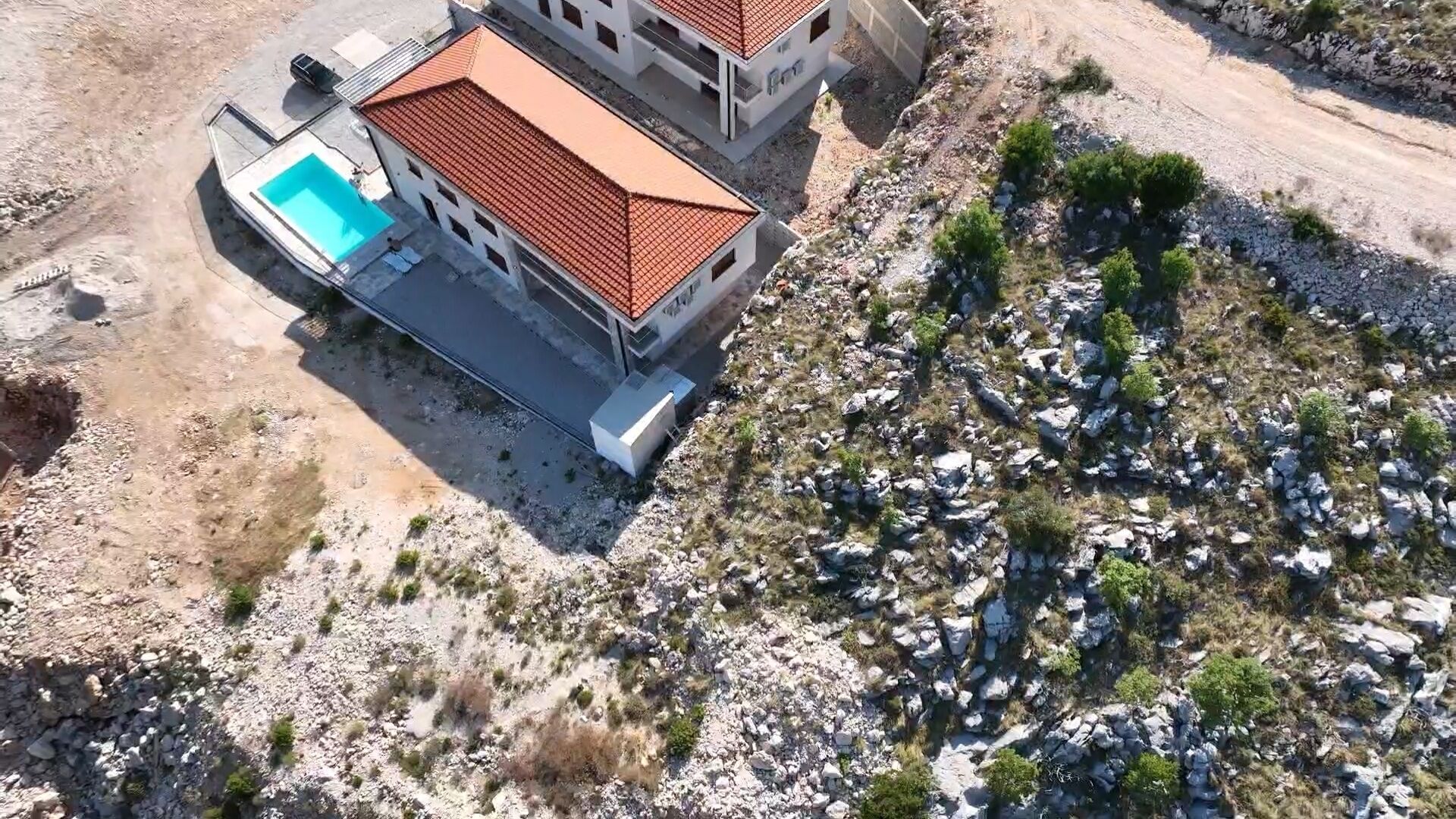 Un bâtiment à deux étages doté d’une piscine et entouré d’un paysage rocheux.