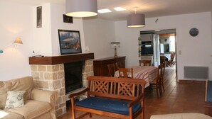 Una sala de estar con chimenea, muebles de madera y un comedor con mesa y sillas.