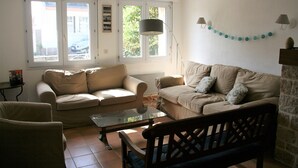 Una sala de estar con dos sofás, una mesa de centro y una lámpara.