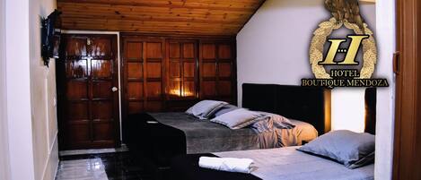 A hotel room with two beds, a wooden ceiling, and a large emblem on the wall.
