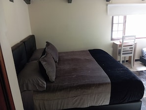 A single bed with a headboard, a desk, and a chair in a room with a window. - Hotel Boutique Mendoza (Bogotá)