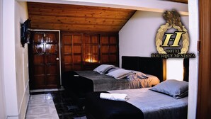 Habitación de hotel con dos camas, techo de madera y un gran emblema en la pared.