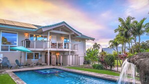 A two-story house with a swimming pool, outdoor seating, and a waterfall feature. - Tropical & Elegant- Sleeps 8- Ocean/Waterfall Views (Princeville)