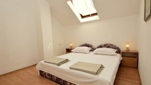 A bedroom with a bed, two bedside tables with lamps, a window, and a patterned carpet. - Margita by Interhome (Brač/Supetar)