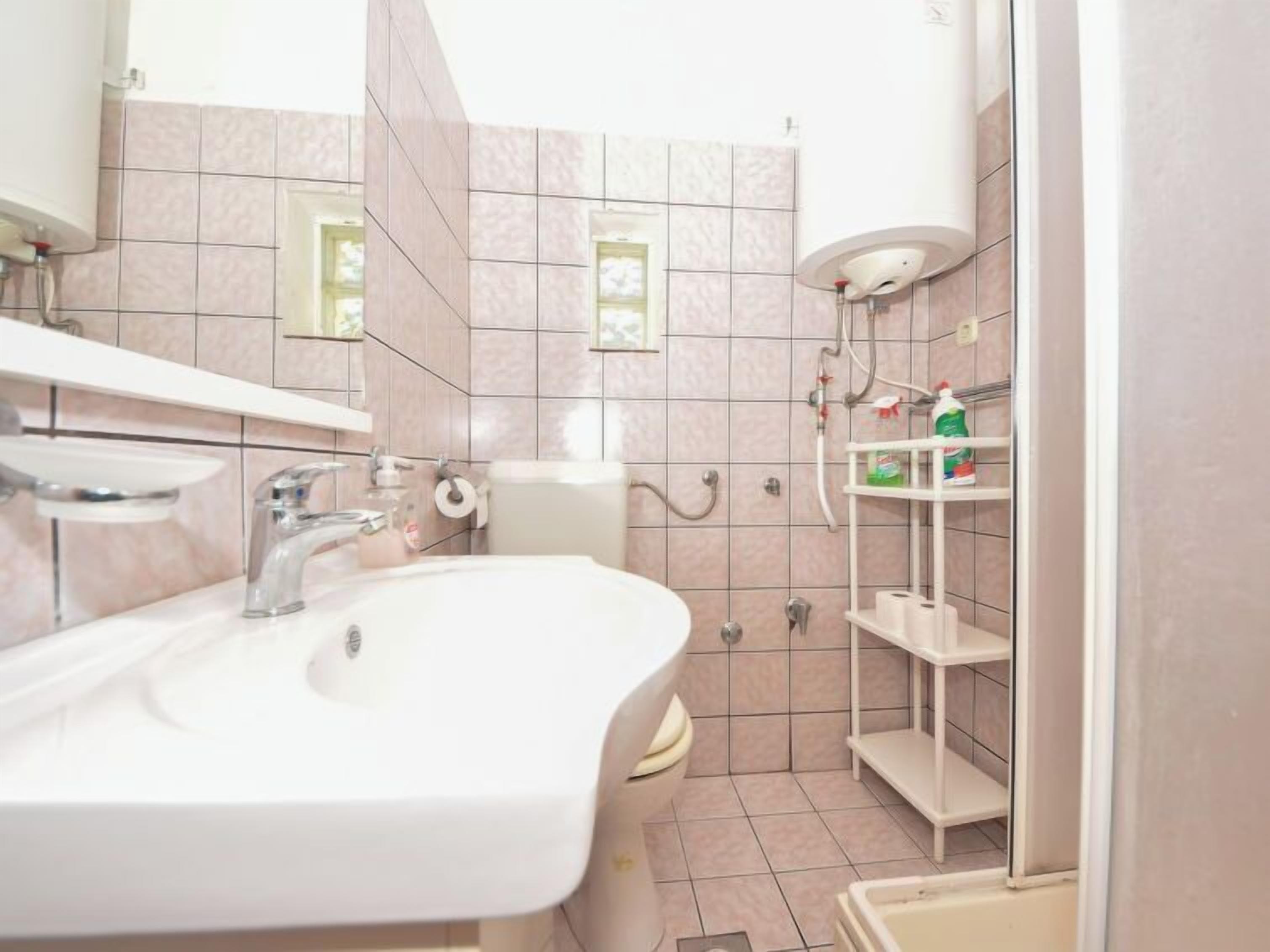 A bathroom with a sink, toilet, and shower area.