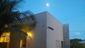 A modern building with a flat facade, a small window, and a decorative panel. - Pousada Laguna (Conde)