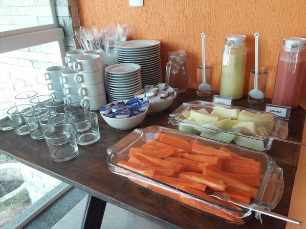 A buffet table with various food items and drink dispensers. - Pousada Laguna (Conde)