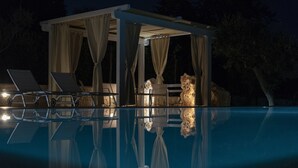 A covered outdoor area with a pool, lounge chairs, and a rock formation. - Stylish Trulli with Private Pool for 4 guests in Puglia (Castellana Grotte)