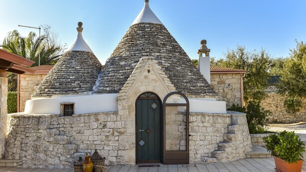 A stone building with a conical roof and a green door. - Stylish Trulli with Private Pool for 4 guests in Puglia (Castellana Grotte)