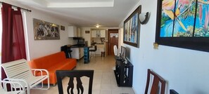 A compact living space with a kitchenette, a dining area, and a sofa.