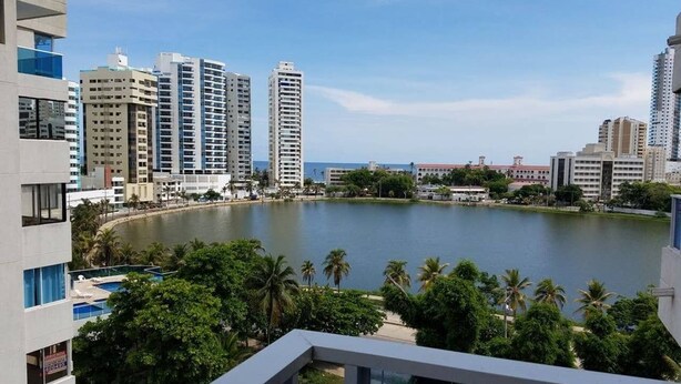 A high-rise building with a view of a lake and surrounding greenery. - Across from the Beach Edificio El Nuevo Conquistador Apto 612 Barrio El Laguito (Cartagena)