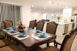 Enjoy meals in a beautifully set dining area with a long table and classic chairs.