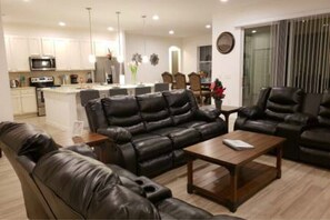 Relax in this stylish living room with a comfortable sofa, dining area, and modern kitchen.