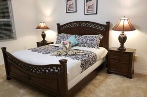 Cozy bedroom with a classic bed, patterned bedspread, and matching nightstands.