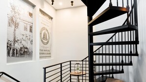 A staircase with a black railing and a small table with a plant.