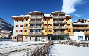Et hotel med flere etager, balkoner, et skilt og et sneklædt landskab.
