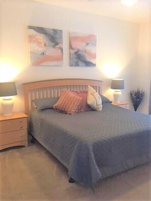 Un dormitorio con una cama, dos mesitas de noche y dos lámparas de pared.