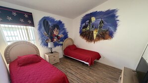A bedroom with two beds, a nightstand, a lamp, and a wall mural. - Daisy's Den - Five Bedroom Home (Kissimmee)