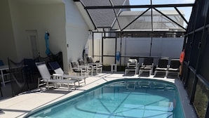 A swimming pool with lounge chairs and a covered area. - Daisy's Den - Five Bedroom Home (Kissimmee)