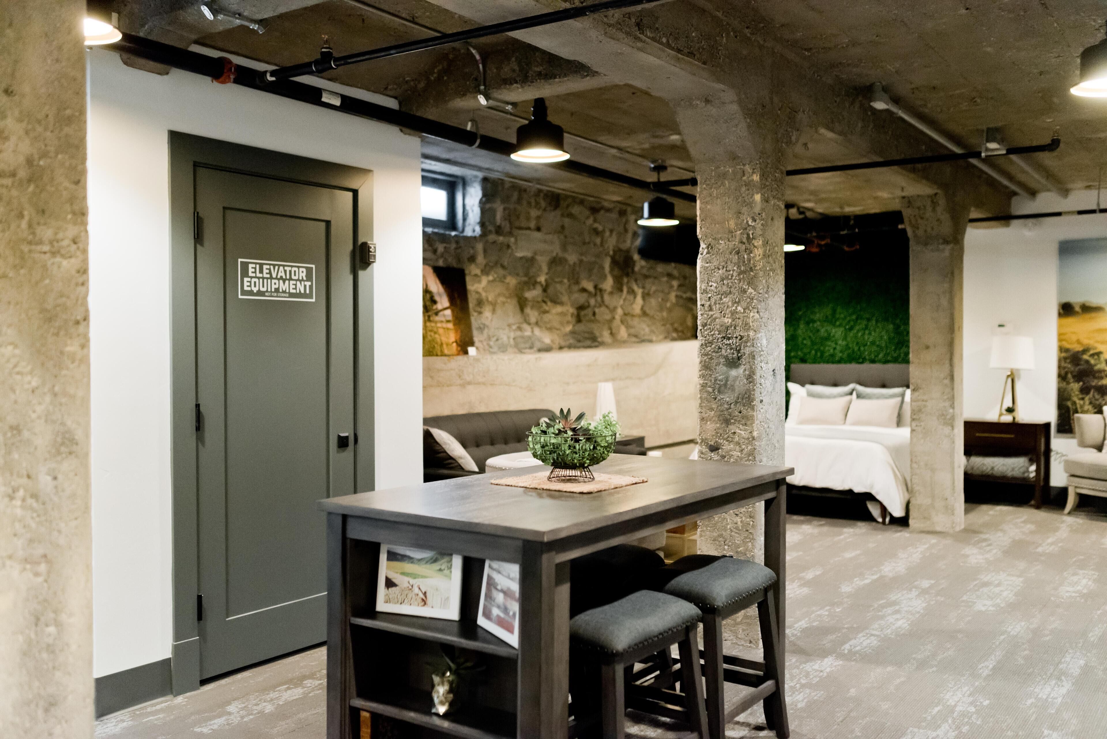 Un intérieur moderne comprenant un coin bar, un lit et un mur en pierre.