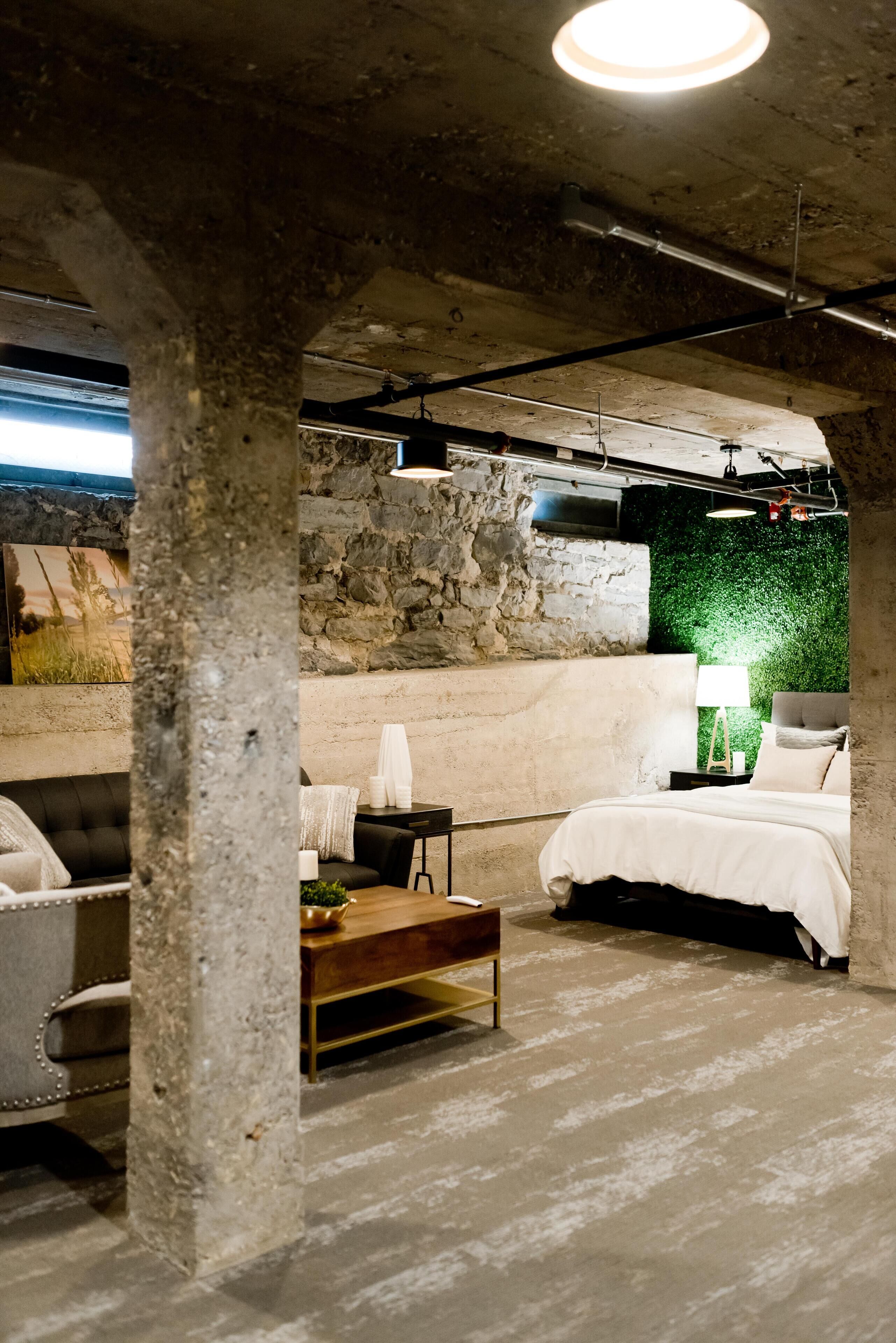 Um quarto com parede de pedra, uma cama, um sofá e uma mesa de centro.