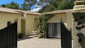 Un pati amb paviment de pedra, una taula amb caires i una porta.