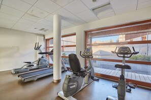 A gym with treadmills, stationary bikes, and elliptical machines.