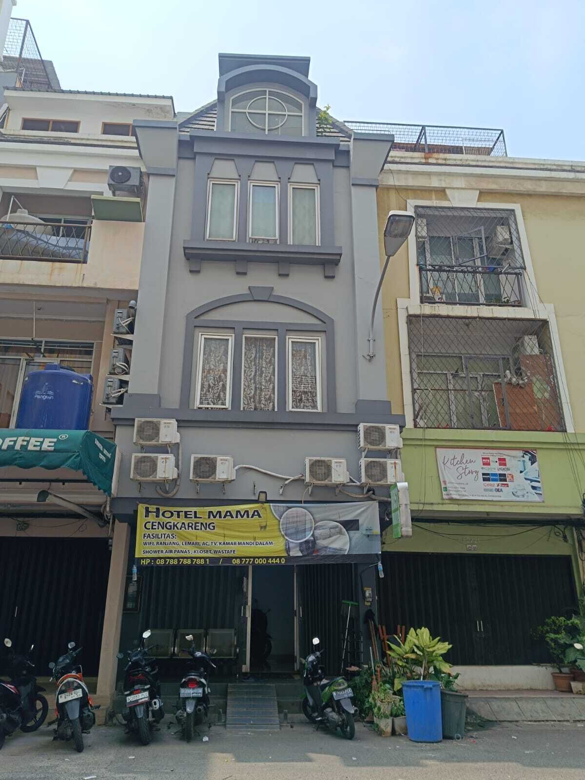 Voici un hôtel dont l’enseigne annonce la présence d’équipements tels que le Wi-Fi, une douche et la climatisation. On peut voir des motos garées devant, et le bâtiment présente un style architectural moderne, avec de nombreuses fenêtres et des unités de climatisation apparentes.