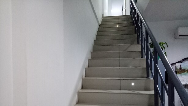 A staircase with a handrail, leading to an upper floor. - Hotel Syariah Mama Cengkareng (Jakarta)