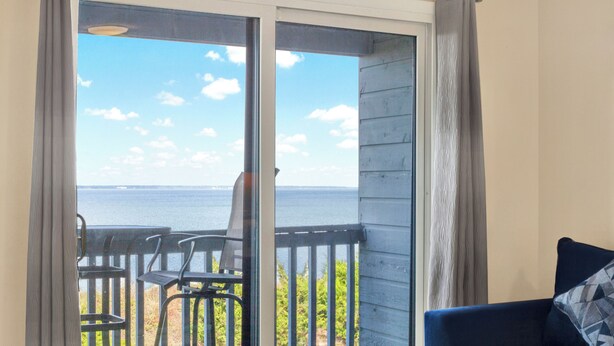 Un balcon avec vue sur la mer, une chaise et un canapé.