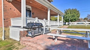 A brick building with a covered patio, a barbecue grill, and picnic tables. - Walk to Parks & Dining: Spacious Ligonier Home! (Ligonier)