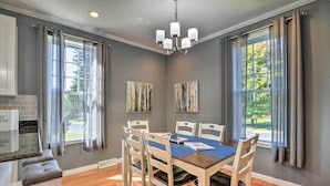 A dining area with a table set for four, surrounded by chairs, a chandelier, and artwork on the walls. - Walk to Parks & Dining: Spacious Ligonier Home! (Ligonier)