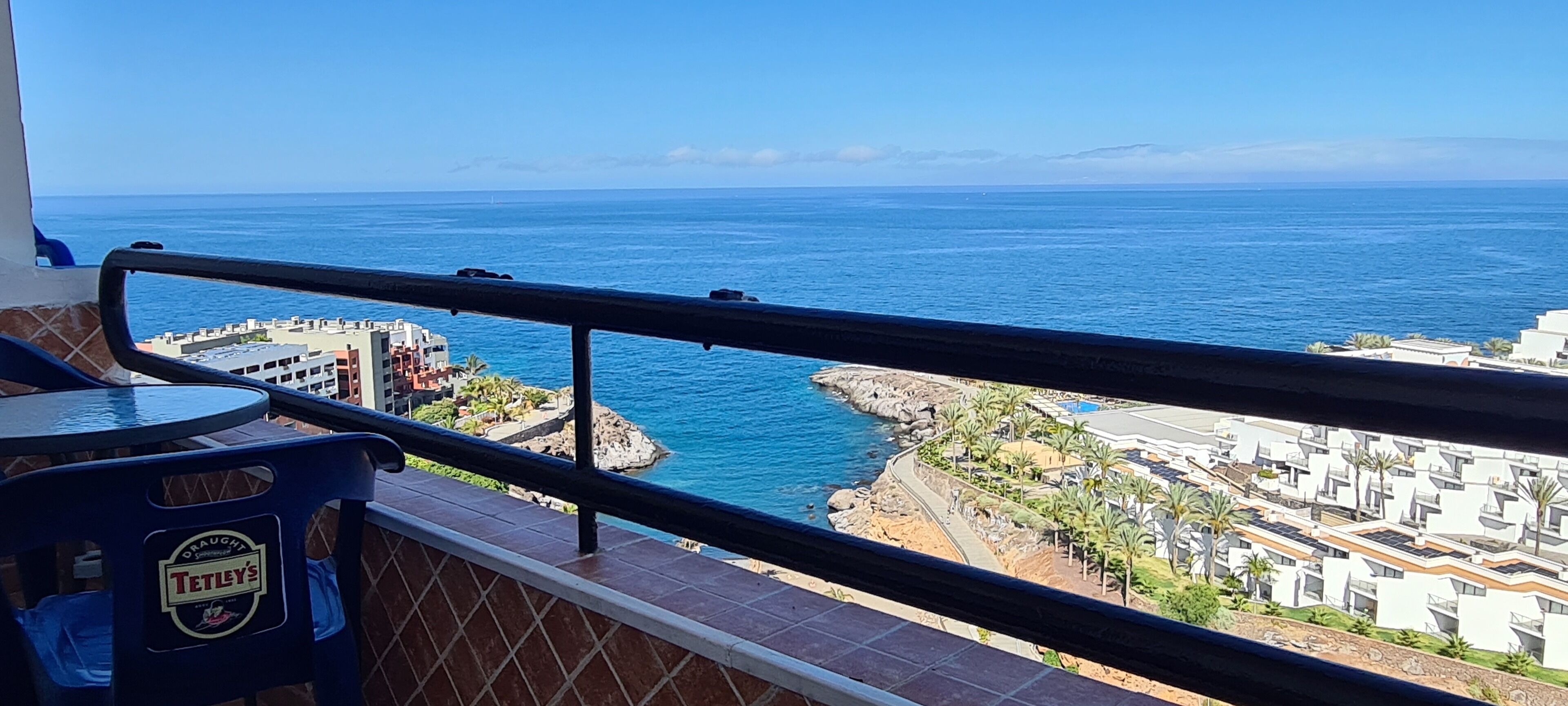 Un balcón con vista al mar y a un pueblo costero.