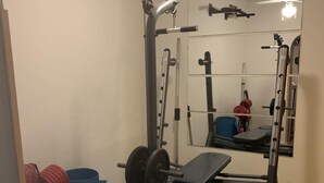 A gym with a squat rack, bench press, and free weights. - Apartment very close to Gran Via Sol WiFi Museums  (Madrid)