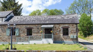 A stone building with a sloped roof, a porch, and a small garden area. - 2 bedroom accommodation in Buckland Brewer, near Bideford (Buckland Brewer, near Bideford)
