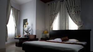 Ein Hotelzimmer mit einem großen Bett, einem Schreibtisch mit Lampe und einem Sessel.